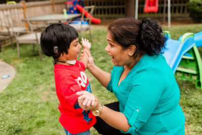 Nurse in teal shirt with child