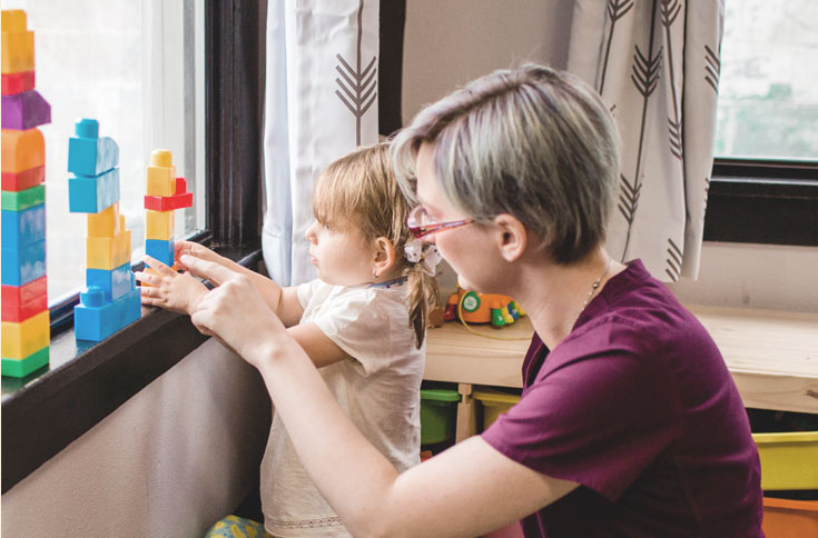 nurse with toddler and toy blocks